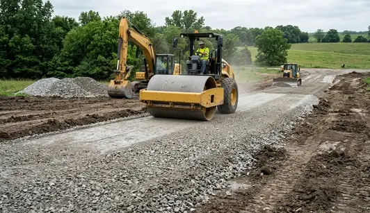Compacting aggregate road base with vibratory roller during driveway construction in North Missouri